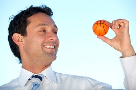 Business man with a small basket ball smiling