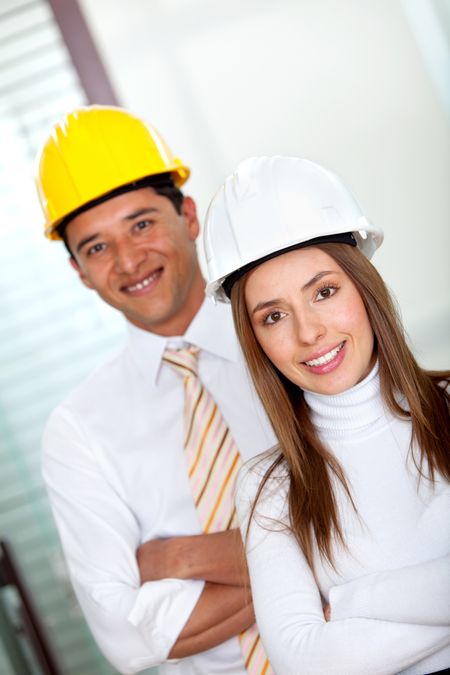 Architects at the office wearing helmets and smiling