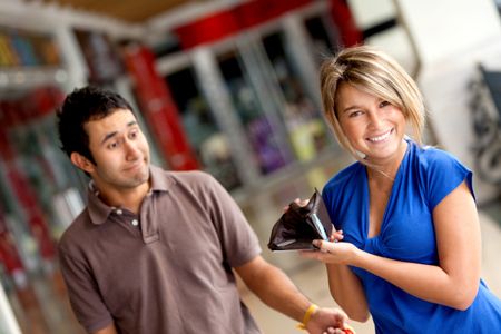 Woman displaying her man's empty wallet at a shopping center