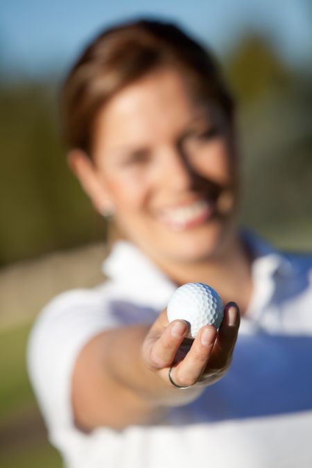 Female golfer holding a golf ball outdoors