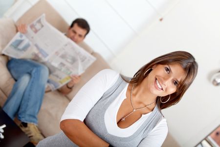 Woman with his boyfriend behind her reading the newspaper