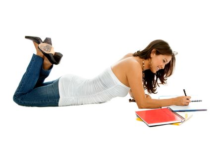 Girl lying on the floor studying isolated over a white background