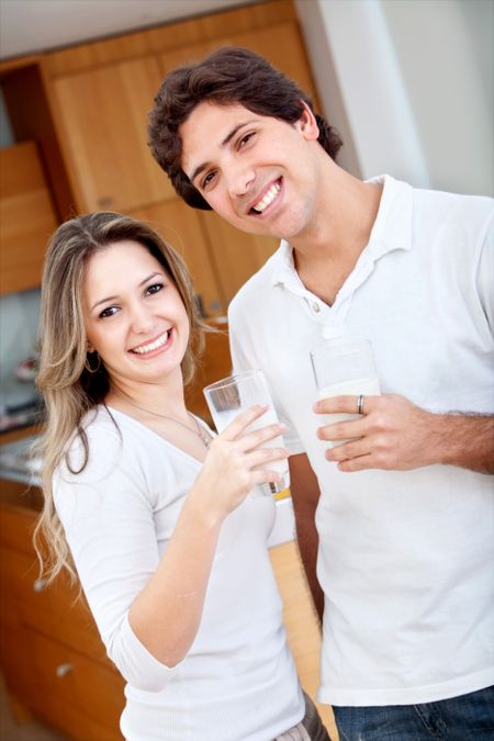Happy couple with a glass of milk indoors