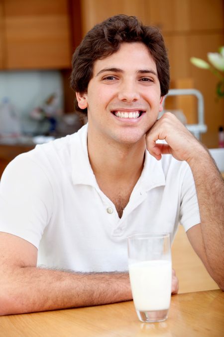 Handsome man with a glass of milk indoors