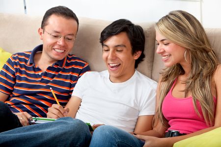 Group of students looking happy sitting on a coach indoors