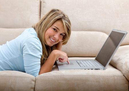 Girl lying on a sofa with a computer