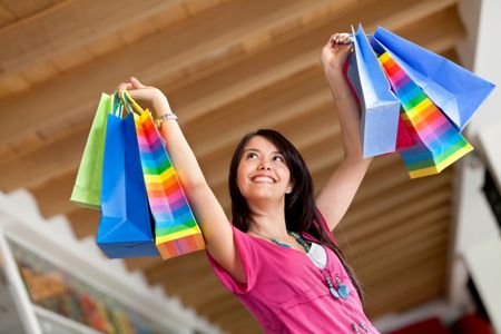 Happy shopping woman lifting some bags and smiling