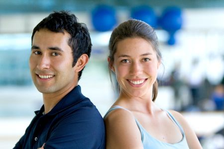 Happy young couple at the gym smiling