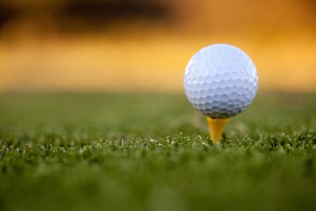 White golf ball lying over grass outdoors