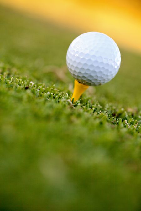White golf ball lying over grass outdoors