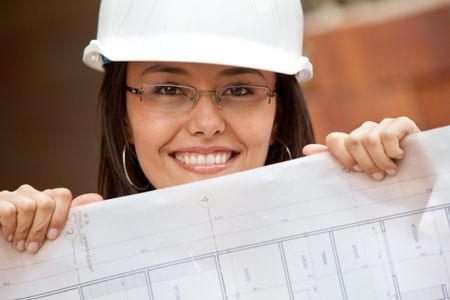Female architect with blueprints at a construction site