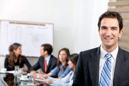 Business man at the office with a group behind