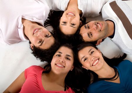 Happy group of friends together lying on the floor isolated on white