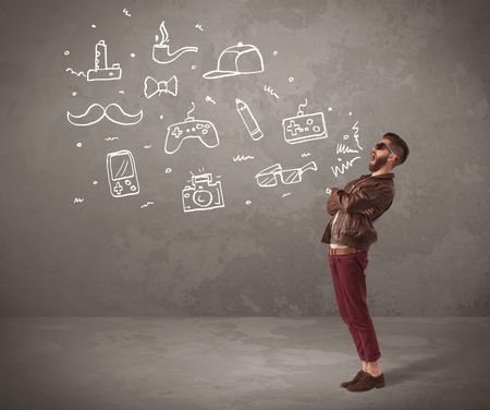 A funny hipster person in casual urban clothing shouting drawn everyday items like camera, tie or pen on city wall concept