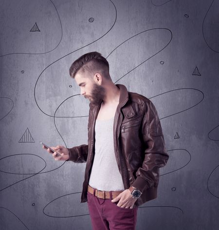 A modern young male in casual fashion style clothing making funny facial expressions while standing