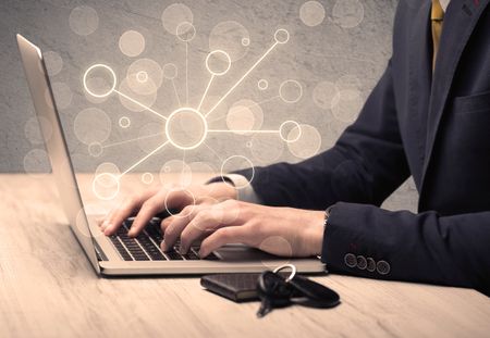 An office salesman in elegant suit working on a scientific project with the help of a laptop concept