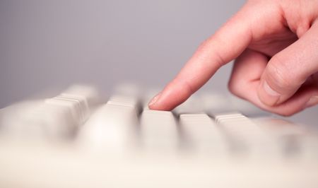 Close up of hand pressing keyboard buttons on desk