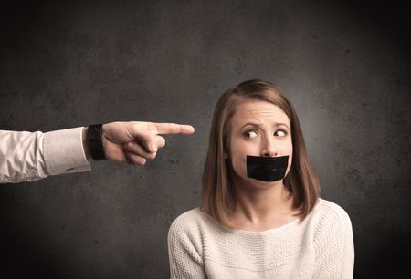 Caucasian business hand pointing at female employee with grunge background