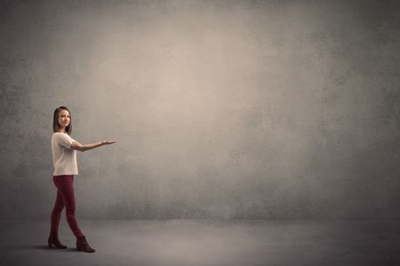 Caucasian woman standing in front of a blank grunge wall