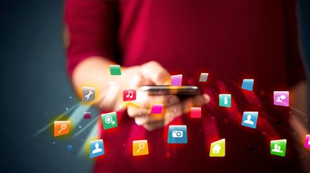 Man holding smartphone with technology application icons comming out