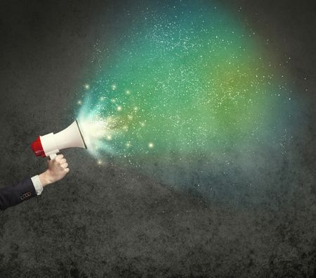 Caucasian business hand holding megaphone with white sparkles on a grunge background