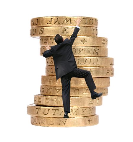 business man climbing some pound coins