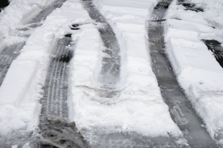 Winter at a glance: tire tracks in snow on parking spaces