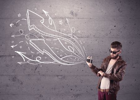 A hipster guy opening his point of view through looking a vintage camera concept with illustratied drawn arrows on urban wall