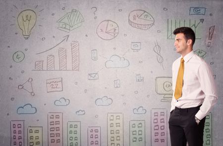 A young adult businessman standing in front of a wall with colorful drawings of buildings, charts, graphs, signs concept