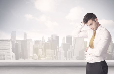 A young adult businessman standing in front of city landscape with skyscraper buildings and clouds concept