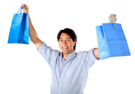 Excited man with arms up holding shopping bags - isolated