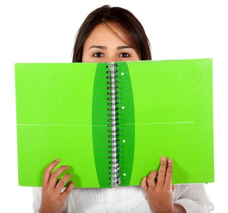 Woman covering her face with a notebook isolated over white