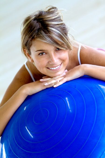 Beautiful female portrait at the gym with a pilates ball