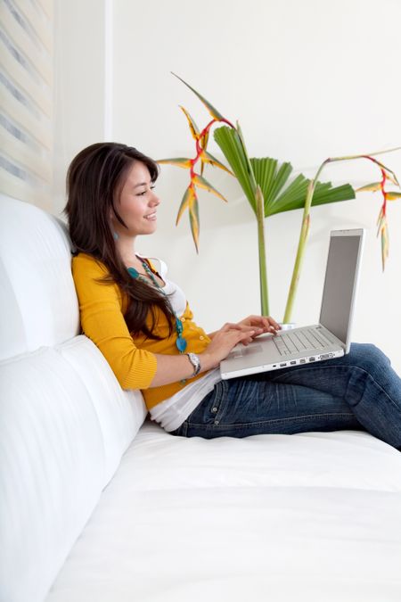 Woman at home sitting on the sofa with a laptop