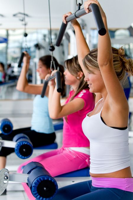 Beautiful women at the gym exercising on machines