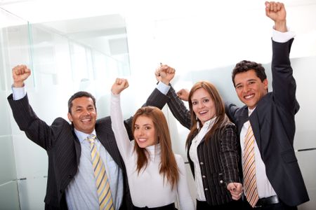 Successful business team with arms up at the office