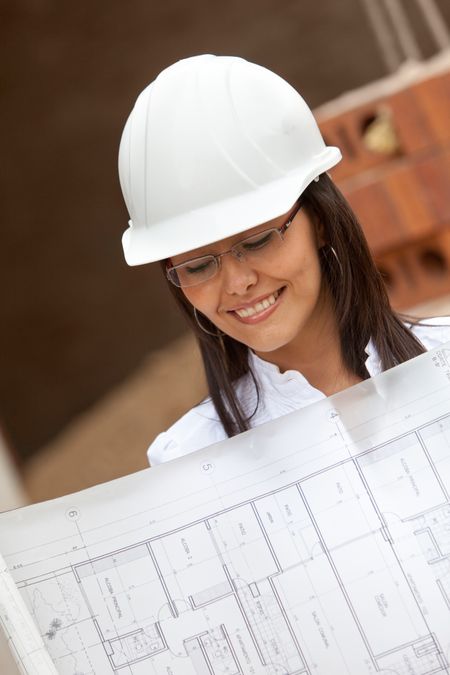 Architect looking at the blueprints at a construction site