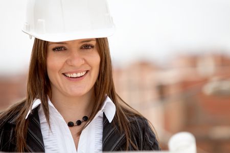 Female architect at a construction site and smiling