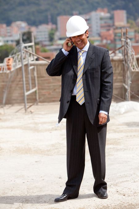Engineer at a construction site talking on the phone