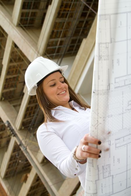 Architect looking at the blueprints at a construction site