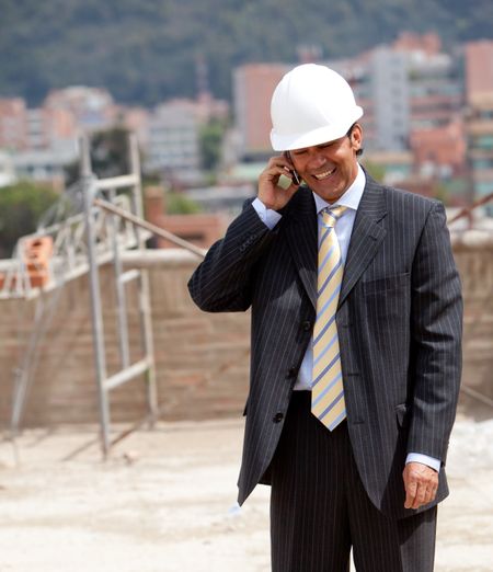 Engineer at a construction site talking on the phone