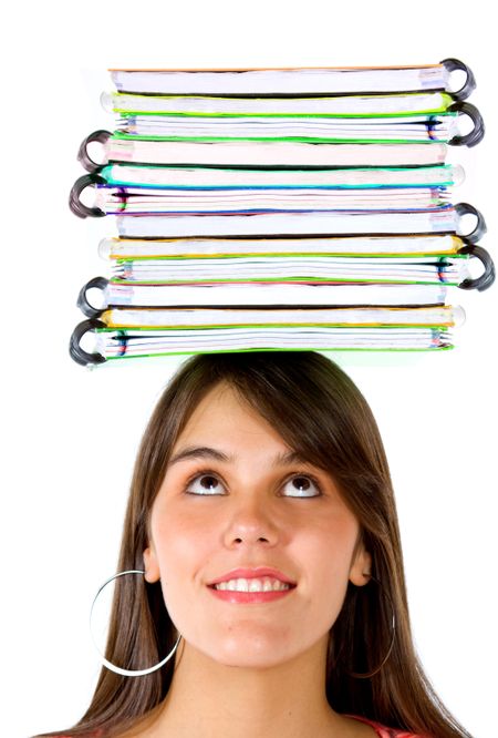 Beautiful female student with notebooks on top of her head isolated over a white background