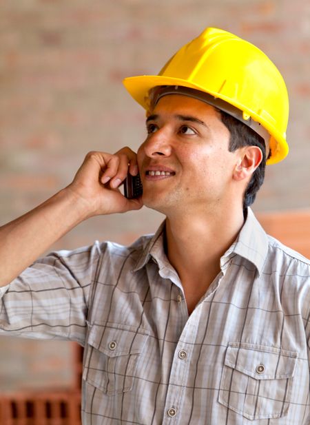 male engineer smiling on the phone in a construction site