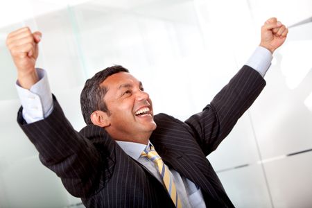 business man standing with his arms up representing his success isolated over a white background