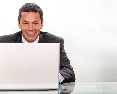 business man looking happy on a laptop in his office