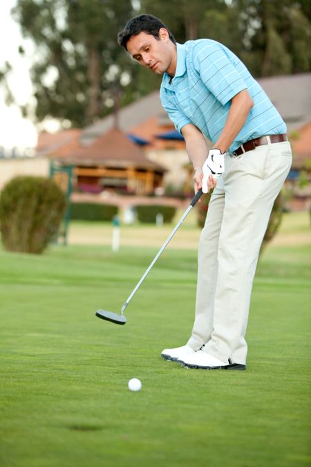 Fullbody young man outdoors playing golf hitting the ball