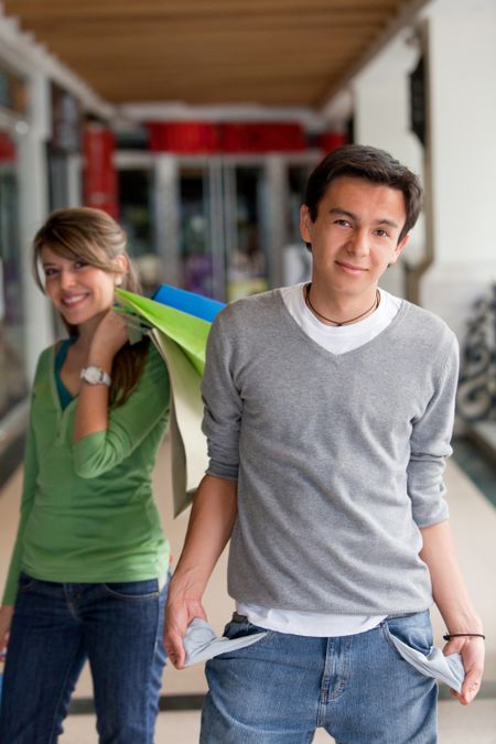 Shopping man with empty pockets and his girlfriend behind