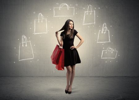 A beautiful young girl in black standing with red shopping bags in front of brown background wall and drawing illustration concept