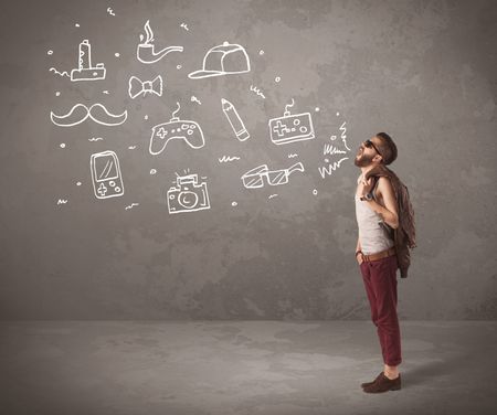 A funny hipster person in casual urban clothing shouting drawn everyday items like camera, tie or pen on city wall concept