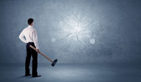 A businessman in modern stylish elegant suit standing on a small ladder and drawing pie and block charts on grey wall background with exponential progressing curves, lines, circles, blocks, numbers